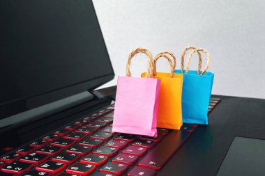 Online alışveriş / e-ticaret ve teslimat hizmeti kavramı: kağıt karton ile bir alışveriş sepeti veya logo üstünde a laptop klavye trolley, perakendeci siteler internet üzerinden gelen müşteriler sipariş şeyler gösteriyor.