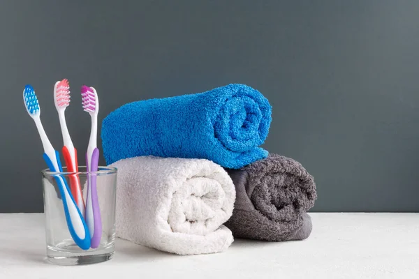 Healthy Teeth Toothbrushes Glass Toothpaste Bath Towels Table Bathroom Gray — Stock Photo, Image