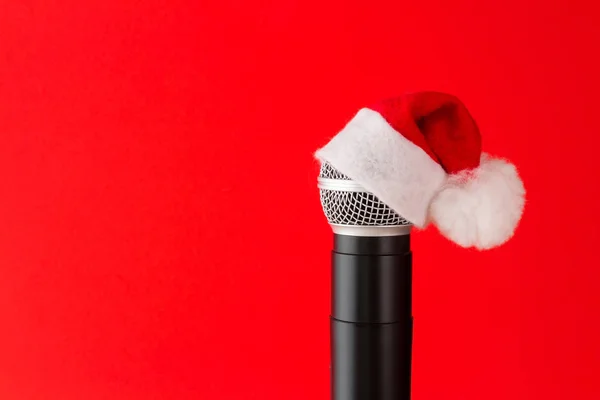 Mikrofon Santa Claus şapka kırmızı bir arka plan üzerinde Noel şenlikli aksesuarlar