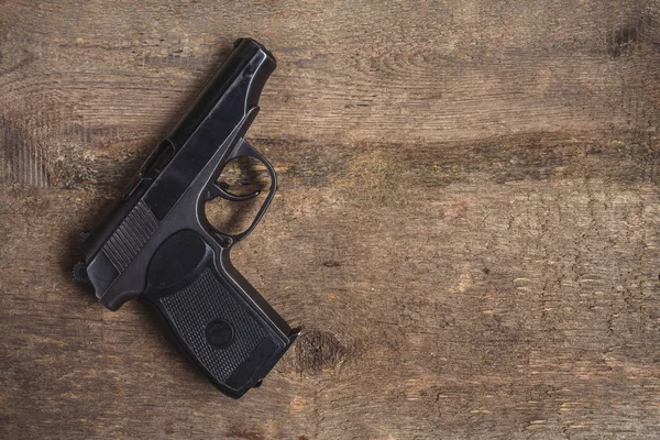 Old army pistol gun, military uniform on a wooden background with copy space, flat lay top view