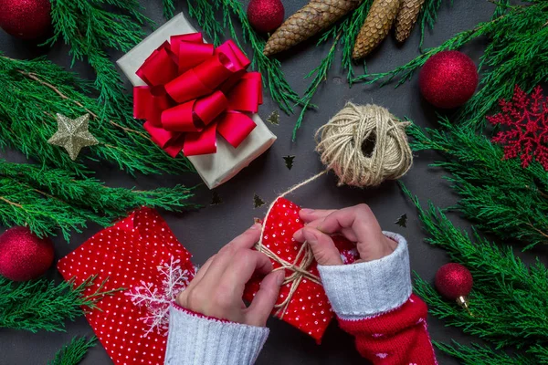 Preparing for holiday, wrapping gifts in hands and various New Year and Christmas accessories