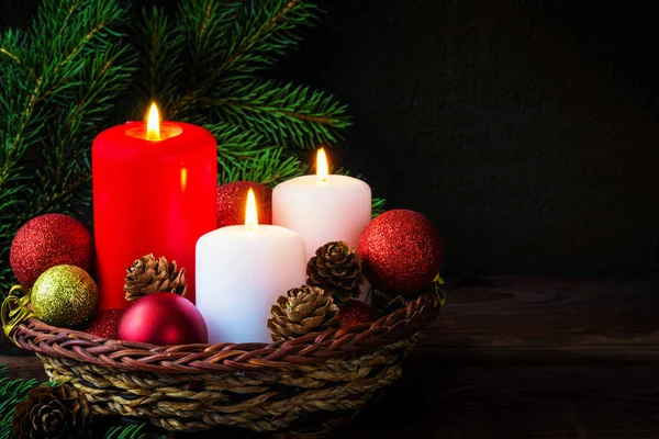 Burning candles in New Year composition with pine branches