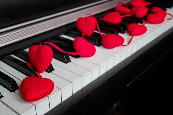 Piano with garland of decoration red hearts