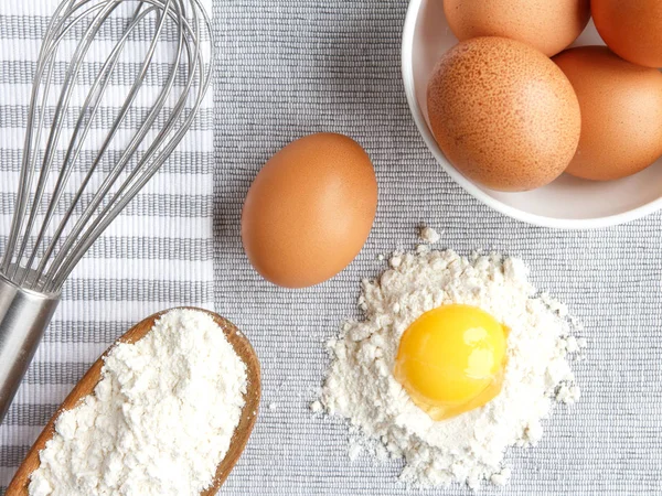 eggs, flour, home baking accessories on gray background