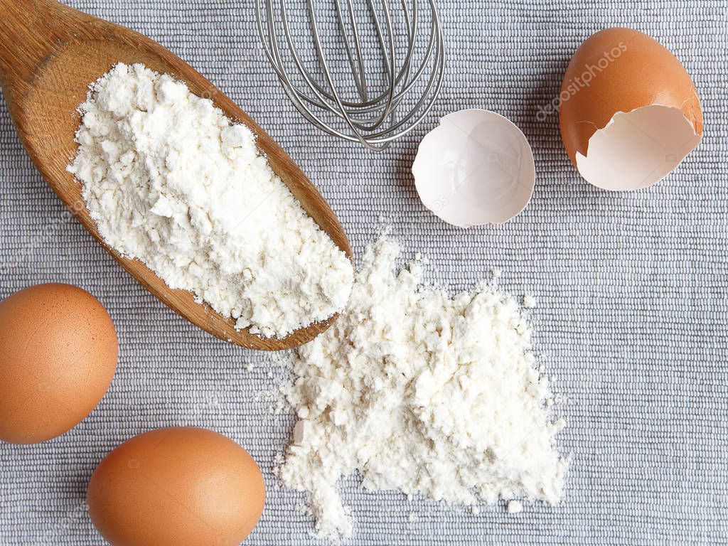 eggs, flour, home baking accessories on gray background