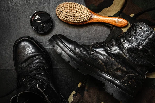 Shoe care. Shoe wax, boot and brushes on wooden surface. Edited image with vintage effect