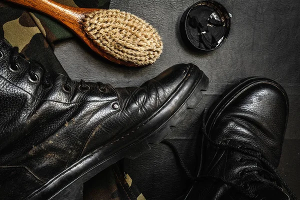 Shoe care. Shoe wax, boot and brushes on wooden surface. Edited image with vintage effect