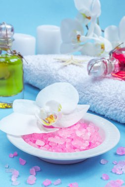 Spa natürmort orkide çiçek, mum, sabun ve havlu ile mavi arka plan üzerinde ayarlama