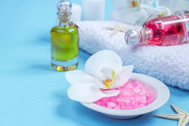 Spa natürmort orkide çiçek, mum, sabun ve havlu ile mavi arka plan üzerinde ayarlama