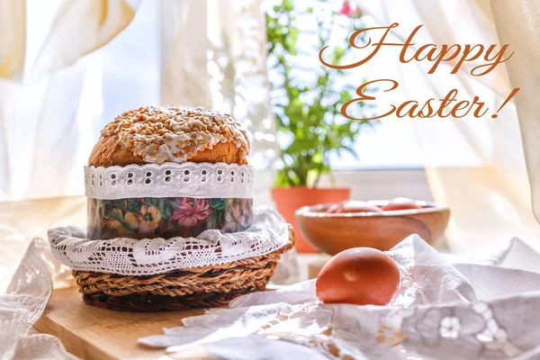 Easter table with Easter cakes and Easter eggs with a flowering branch in a vase on the table by the window, Easter background with the inscription Happy Easter
