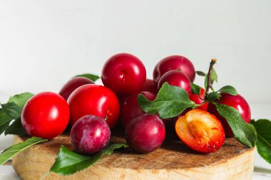 Ahşap açık renkli yapraklarda ile taze kırmızı Erik