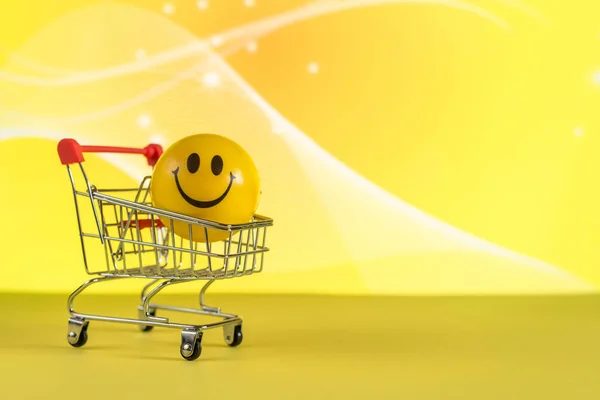 Sorria em uma cesta de compras em um fundo amarelo no Dia das Mentiras de abril com texto Dia das Mentiras de abril, humor, piada — Fotografia de Stock