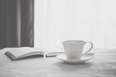 kahve, bir kopya alanı içeren bir pencere önünde masada kareli defter