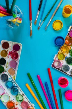 mavi bir arka plan üzerinde sanatsal fırçalar ve boyalar