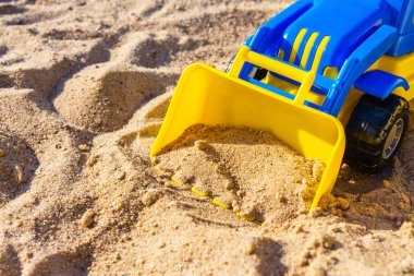 Sandbox ve sarı ekskavatör makinesi ile çocuk plastik mavi kopya alanı ile yakın çekim, çocuk açık oyun konsepti 
