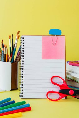 Okul ve ofis malzemeleri sarı tahta önünde sınıf masasında. Kopya alanı konsepti ile okula geri dön 