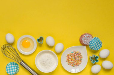 Paskalya fırınkavramı, ev pişirme için çeşitli ürünler, şeker, yumurta ve un, hindistan cevizi munt, üst görünüm, pop art mocap düzeni tarzında sarı bir arka plan metin için boş alan 