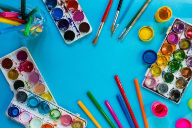 mavi bir arka plan üzerinde sanatsal fırçalar ve boyalar