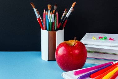 Okul ve ofis malzemeleri mavi siyah tahta önünde sınıf masasında. Kopya alanı konsepti ile okula geri dön 