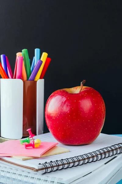 Group of school supplies and books apple on blue background