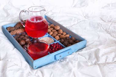 Kopya alanı ile beyaz bir battaniye üzerinde bir tepsi üzerinde bir tepsi üzerinde bir cam kase kızılcık, reçel ve çilek çilek meyve suyu içmek, sağlıklı sağlıklı kahvaltı ve tatlı kavramı 