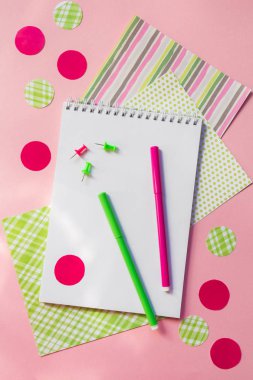 Pembe ve yeşil işaretleri ve not defteri kopya alanı ile pembe arka plan düz üst görünüm üzerinde yazmak için, okul için kırtasiye aksesuarları desen 
