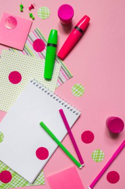 Pembe ve yeşil işaretleri ve not defteri kopya alanı ile pembe arka plan düz üst görünüm üzerinde yazmak için, okul için kırtasiye aksesuarları desen 