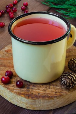 Ladin dalları ve soğuk ve ısınma tıbbi içecekler kopya alanı kavramı ile koniler ile koyu bir arka plan üzerinde bir demir fincan kızılcık suyu İçecek