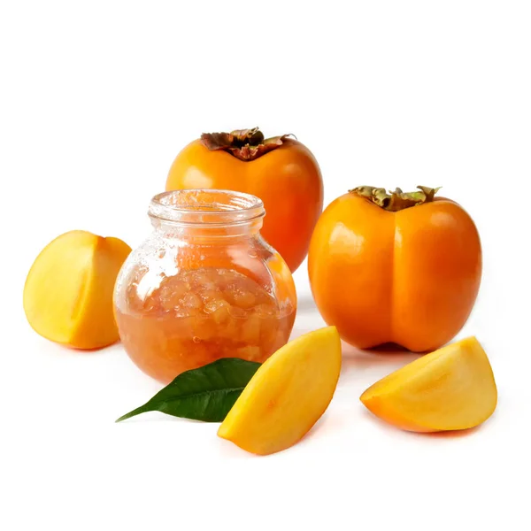 Persimmon fresh juicy fruit and jam in a glass jar on a white background isolated close-up