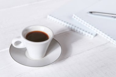 Dizüstü bilgisayar, bir fincan kahve, kağıt boş, kalemler ile şık çalışma alanı. İş konsepti. Düz döşeme, üst görünüm