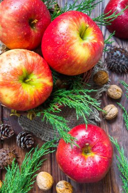 taze olgun elma ve ceviz, ahşap arka plan üzerinde koniler