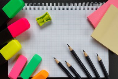 Okul aksesuarları marker, kalem, makas, silgi, ataç, ataç, kopya alanı ile karanlık bir arka plan üzerinde fırça. Kavram okula geri