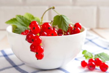 Beyaz bir kapta sulu taze çiğ kırmızı frenk üzümü meyveleri. Sağlıklı bir vitamin diyet vejetaryen tatlı kavramı. Alan seçici odağı kopyalama