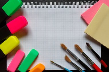 Okul aksesuarları marker, kalem, makas, silgi, ataç, ataç, kopya alanı ile karanlık bir arka plan üzerinde fırça. Kavram okula geri