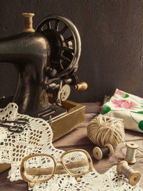 Eski antika dikiş makinesi, iplik, gözlük kavramı el emeği, hobiler ve tarihçesi