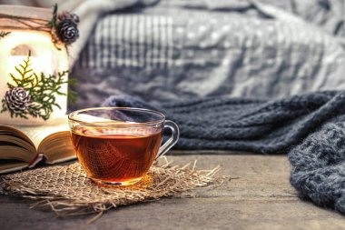 oturma odasında bir su ısıtıcısı ve ahşap bir masa, coziness kavramı üzerine bir kitap ile çay içme natürmort çay