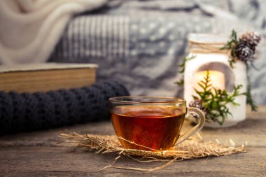 oturma odasında bir su ısıtıcısı ve ahşap bir masa, coziness kavramı üzerine bir kitap ile çay içme natürmort çay