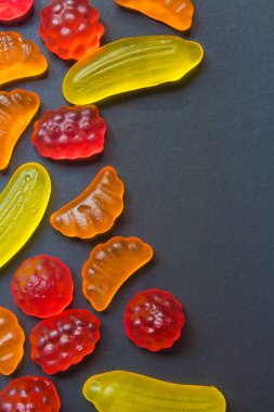 Şablon arka plan için koyu bir arka plan üzerinde tatlılar çok renkli marmelat