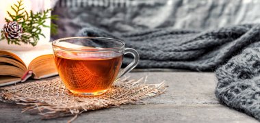 oturma odasında bir su ısıtıcısı ve ahşap bir masa, coziness kavramı üzerine bir kitap ile çay içme natürmort çay