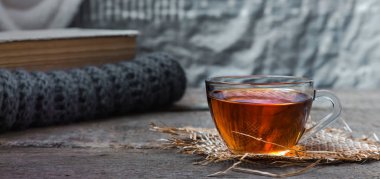 oturma odasında bir su ısıtıcısı ve ahşap bir masa, coziness kavramı üzerine bir kitap ile çay içme natürmort çay