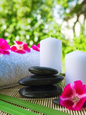 Mumlar, çiçekler, yeşil arka planda taşlar masaj rahatlaması için.