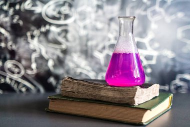 Laboratuvarın arka planına karşı reaksiyon sırasında renkli sıvı ile dolu bir kimyasal laboratuvarda cam, kimyasal deneyim, tıpta teknolojiler, ilaç