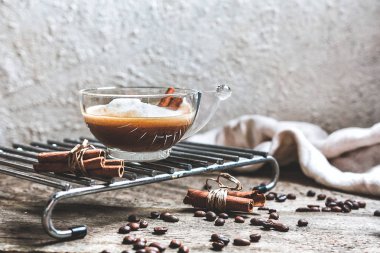 bir fincan kahve ve kahve çekirdekleri tarçın ile natürmort ahşap bir masa üzerinde oturma odasında sopa, Konfor ve İskandinav tarzı hugge iç kavramı