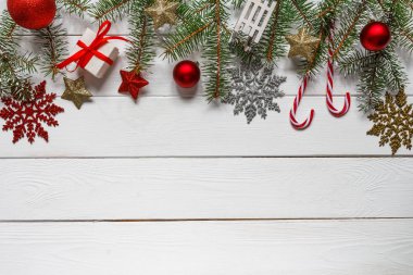 Noel kompozisyonu. Noel hediyesi, örgü battaniye, çam kozalakları, tahta beyaz arka planda köknar dalları. Düz konum, üst görünüm, kopyalama alanı