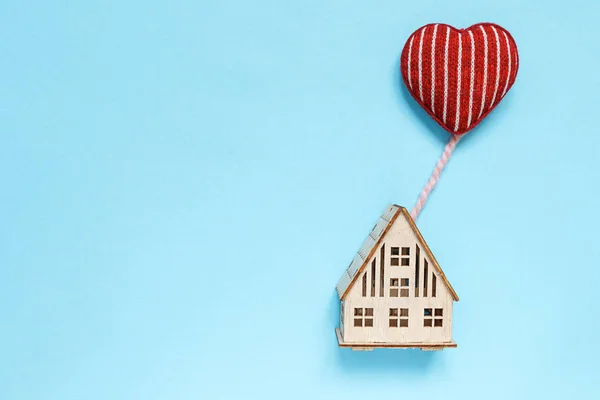 düz üst görünümü, kalp şeklinde bir balon üzerinde uçan kalp ile ahşap ev, aile kavramı, ev, hediye, pastel arka plan sevgililer günü