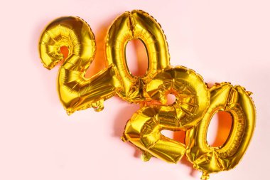 Noel manzarası düzdü. 2020 şişirilebilir altın sayılar. Yılın sembolü. Pembe arka planda sıçan. Noel kış süsü, bayram sembolü, parti. Noel kartı..