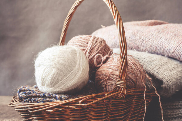 Knitted from a gray yarn sweater and thread for knitting closeup. Knitting as a hobby. Accessories for knitting.