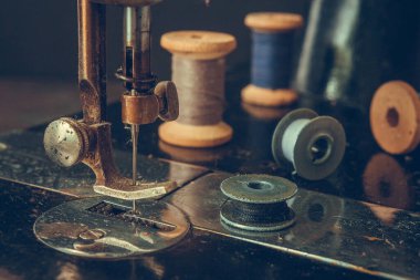 Eski dikiş makinesi retro, kaba bir planın detayları, iplik sargıları, klasik tarzda, bir terzi giysi tarihi seçici odaklanma konsepti.