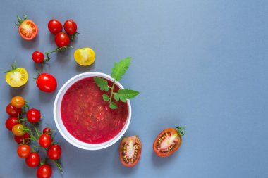 Sebzeler. Taze domates ve sos kompozisyonu ve cam kavanozda bir sos açık mavi arka planda fotokopi alanı, desenli bir çerçeve düz bir çerçeve, üst görünüm