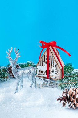 Noel Baba 'nın Noel geyiği hediye evi olan bir kızak taşıyor. Hayallerin ve hayallerin sembolü, mavi arka planda emlak satın almak.